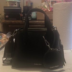 It a mini small Calvin Klein purse it’s a cross body black and silver